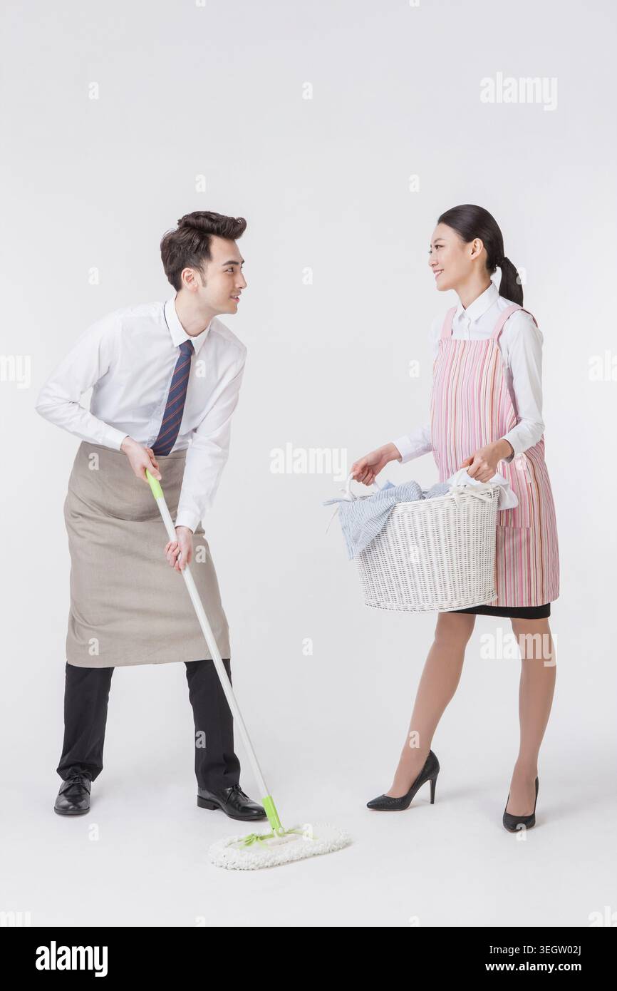 Young harmonious couple doing chores Stock Photo