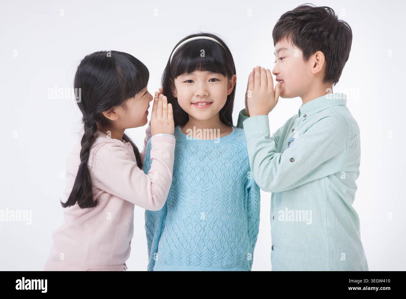 two girls and a boy whispering to each other Stock Photo - Alamy