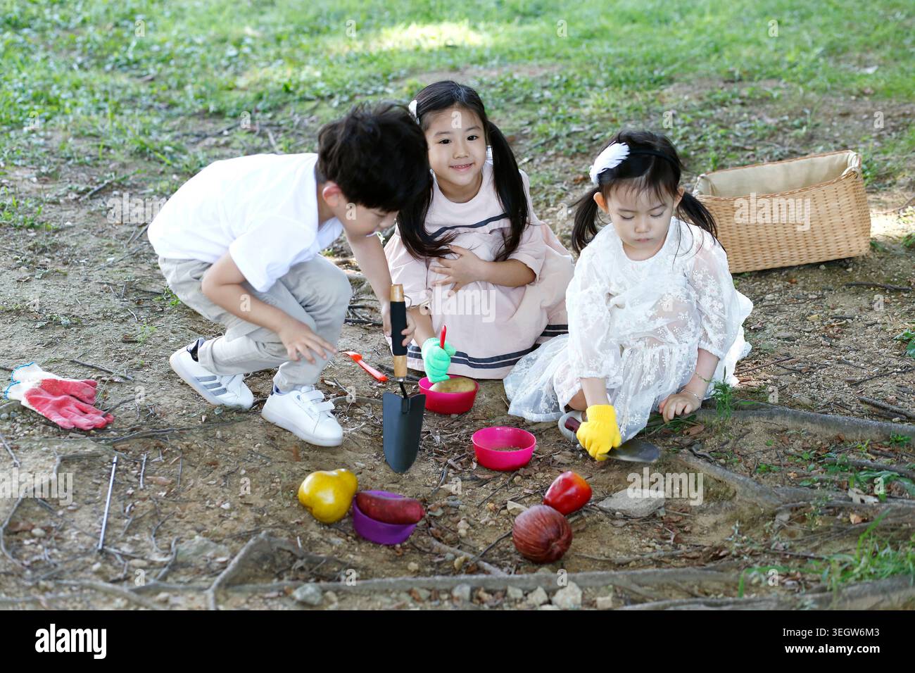 Three children playing sandbox hi-res stock photography and images