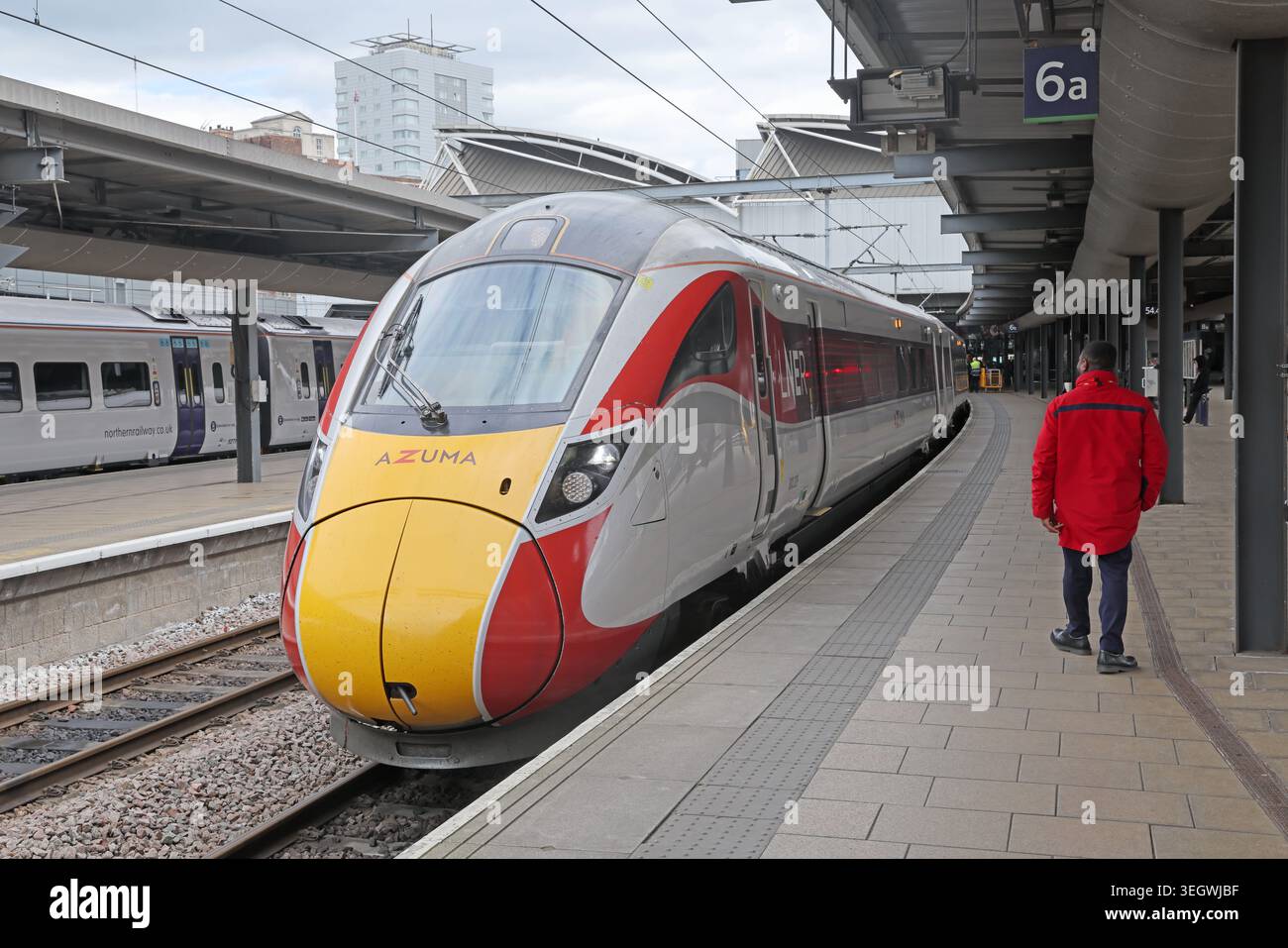 LNER Azuma Class 800 train 800209 beside a railway staff member on platform 6a at Leeds station, West Yorkshire, England, UK Stock Photo