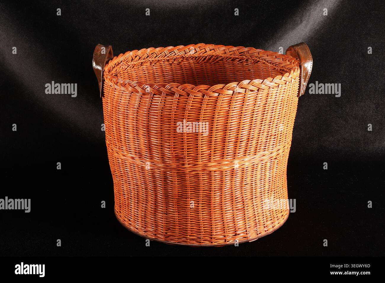 Handmade wicker basket on a black background. Stock Photo