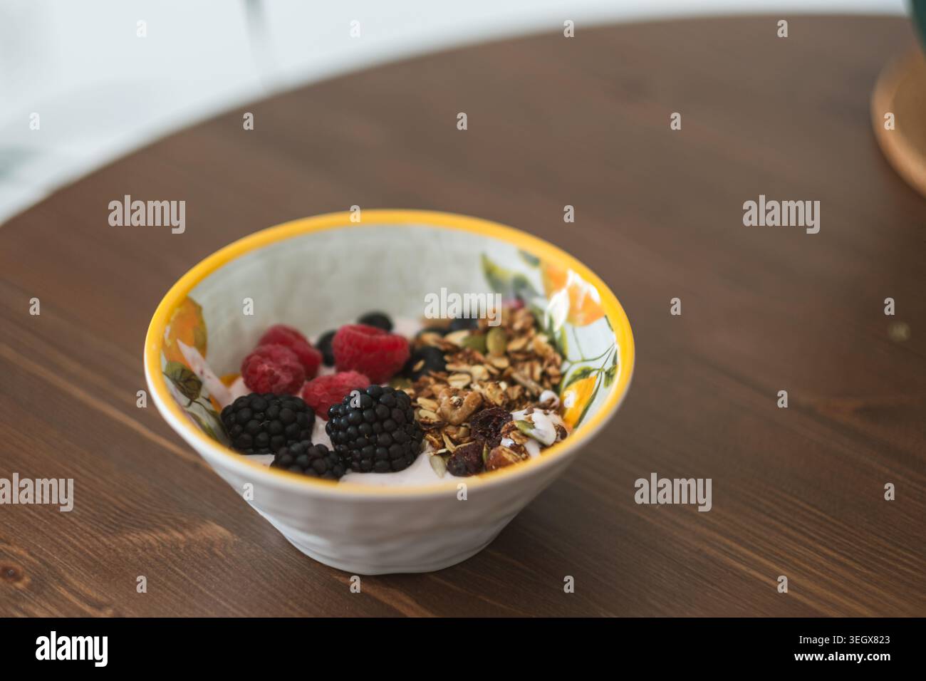 Healthy smoothie bowl with fresh berries and granola on rustic wooden dining table Stock Photo