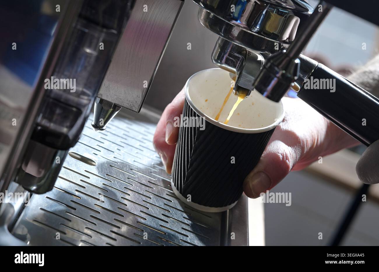 barista making coffee in cardboard cup on coffee machine Stock Photo