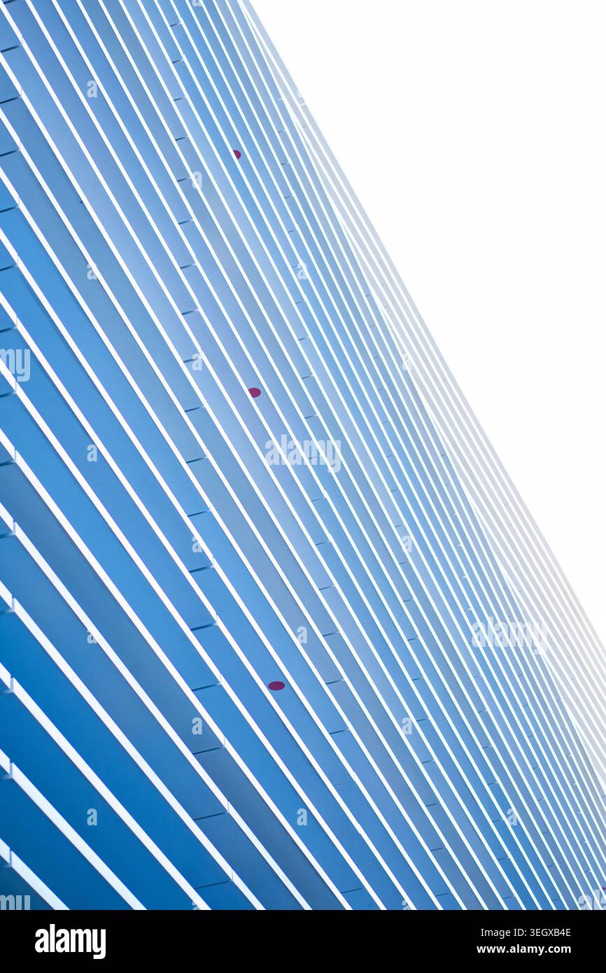 Modern building facade featuring abstract blue and white parallel lines Stock Photo
