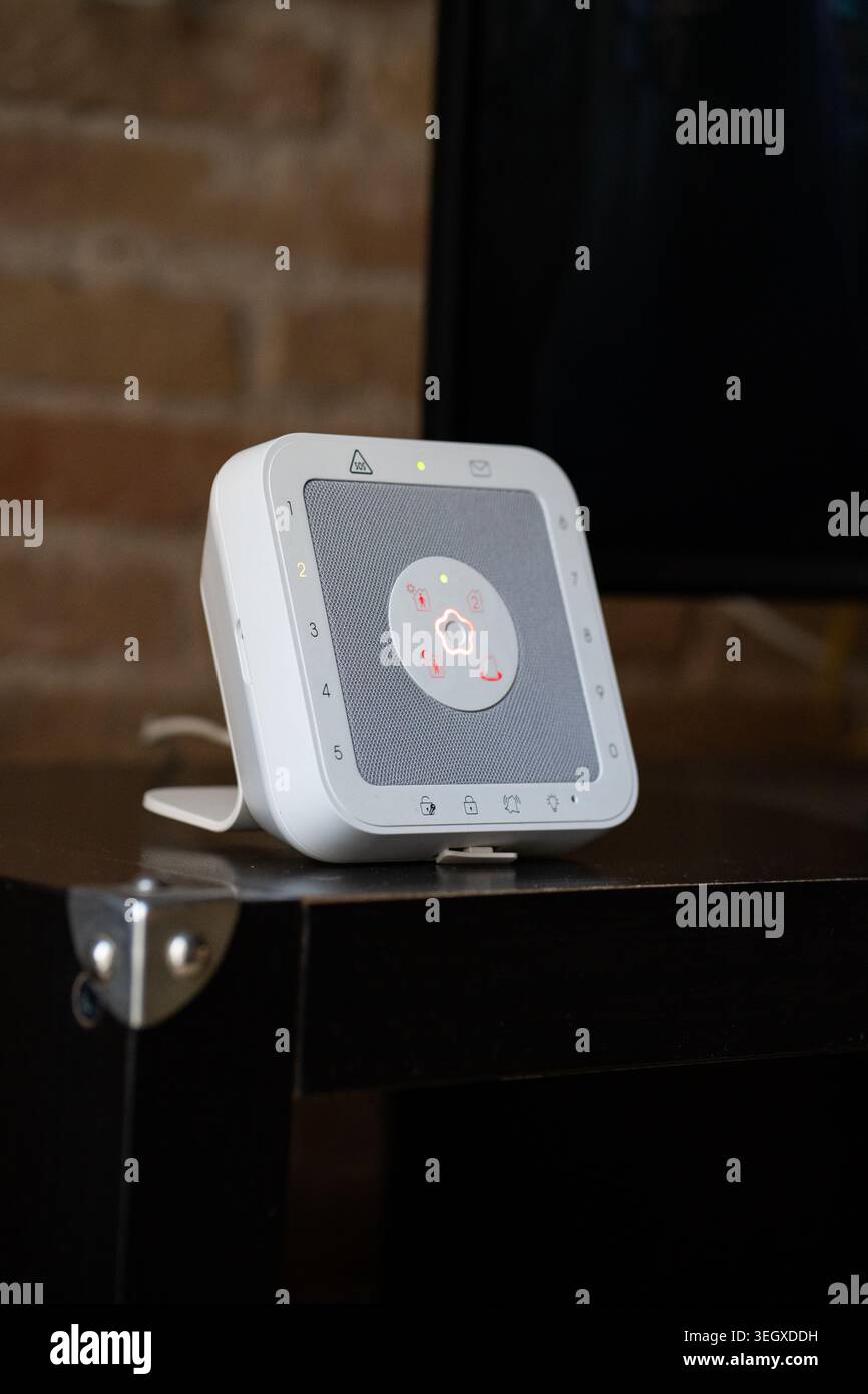 White smart home security hub displaying a central illuminated status light Stock Photo