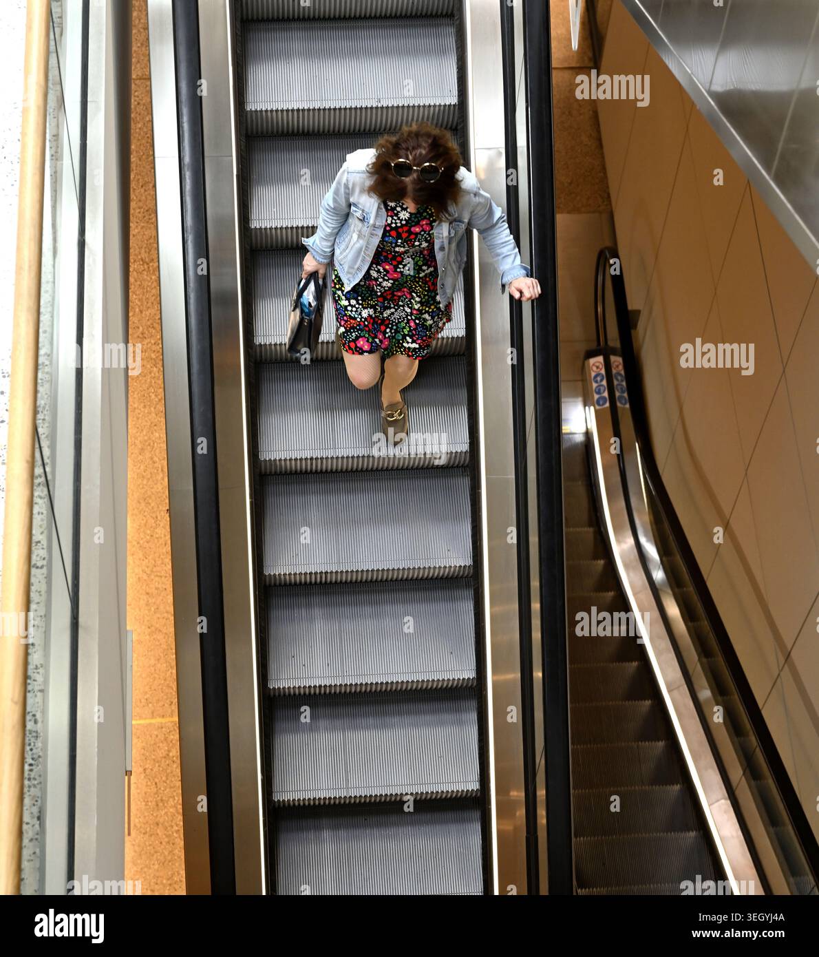 Above woman on down escalator Stock Photo