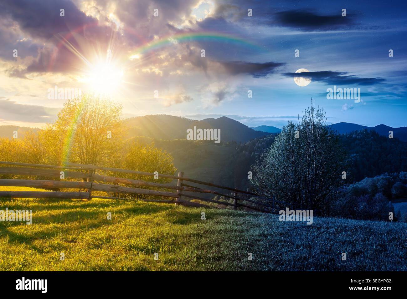 day meet night in mountainous rural landscape in spring. epic view of valley fields at twilight. sun and moon over alpine meadow. carpathian mountains Stock Photo