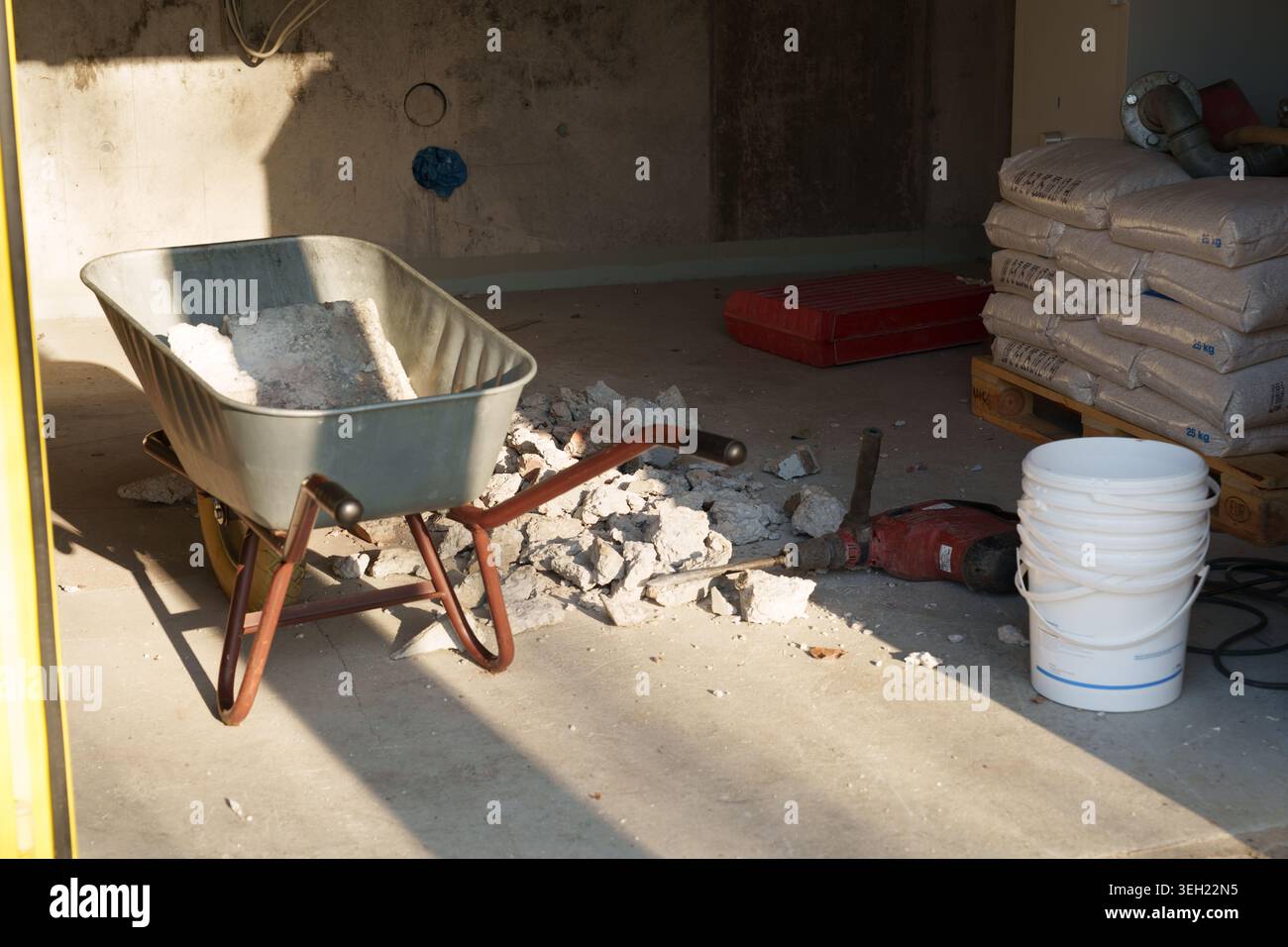 Construction work tools and debris in unfinished interior space Stock Photo