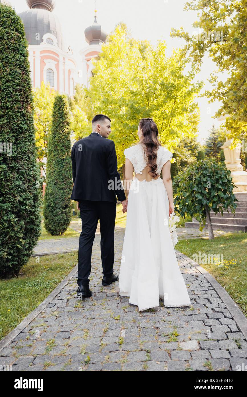 Couple walks hand in hand down stone path Stock Photo