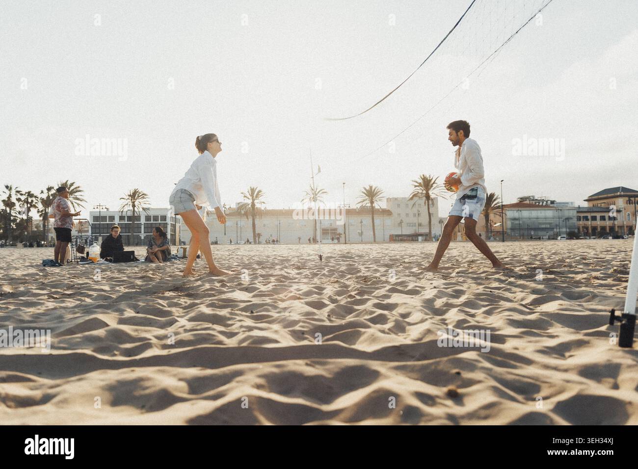 Sunlit beach, two players in motion Stock Photo