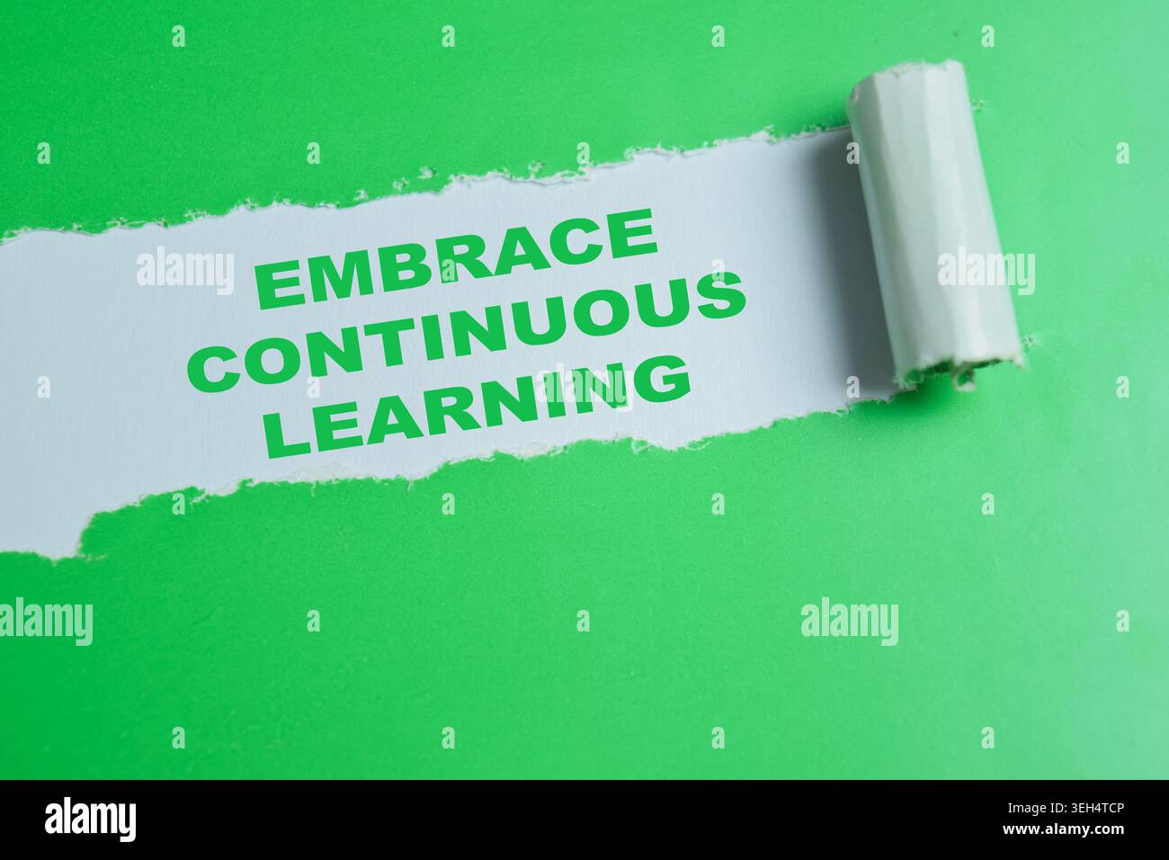 Embrace continuous learning text written in torn paper. Stock Photo