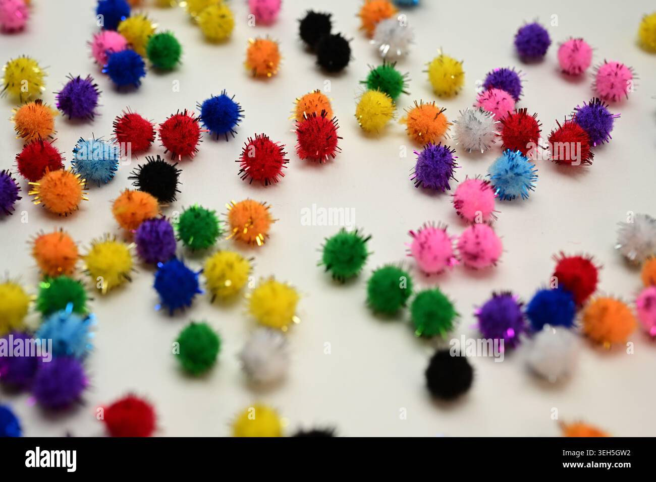 Colorful interlocking hook construction balls scattered on a white surface, creative children's educational building toy pieces in a bright layout. Stock Photo