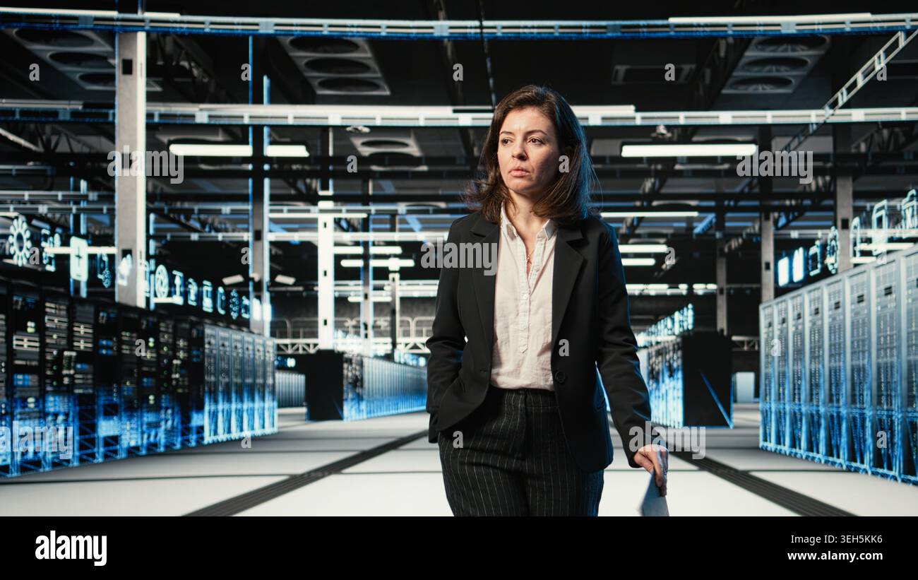 Data center manager inspecting blue wireframe mesh hardware rackmounts. System administrator walking through server hub rows, looking at AR digital twin data streams Stock Photo