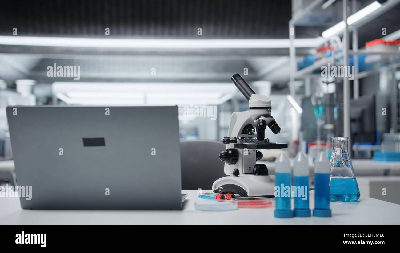 Close up of laptop on laboratory workbench next to scientific ...