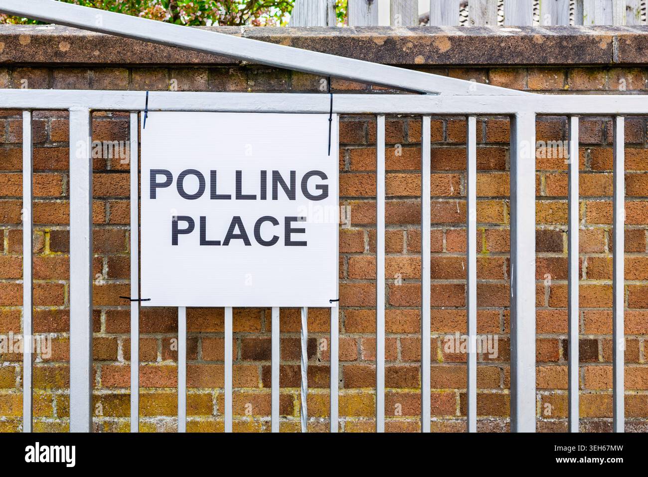 Polling place sign secured to a metal gate outside a voting location ...