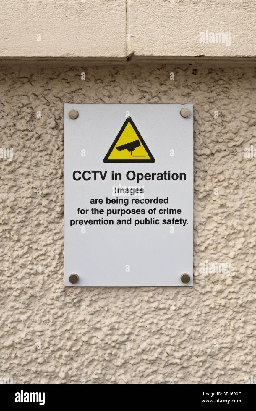 CCTV in operation warning sign mounted on a textured exterior wall ...