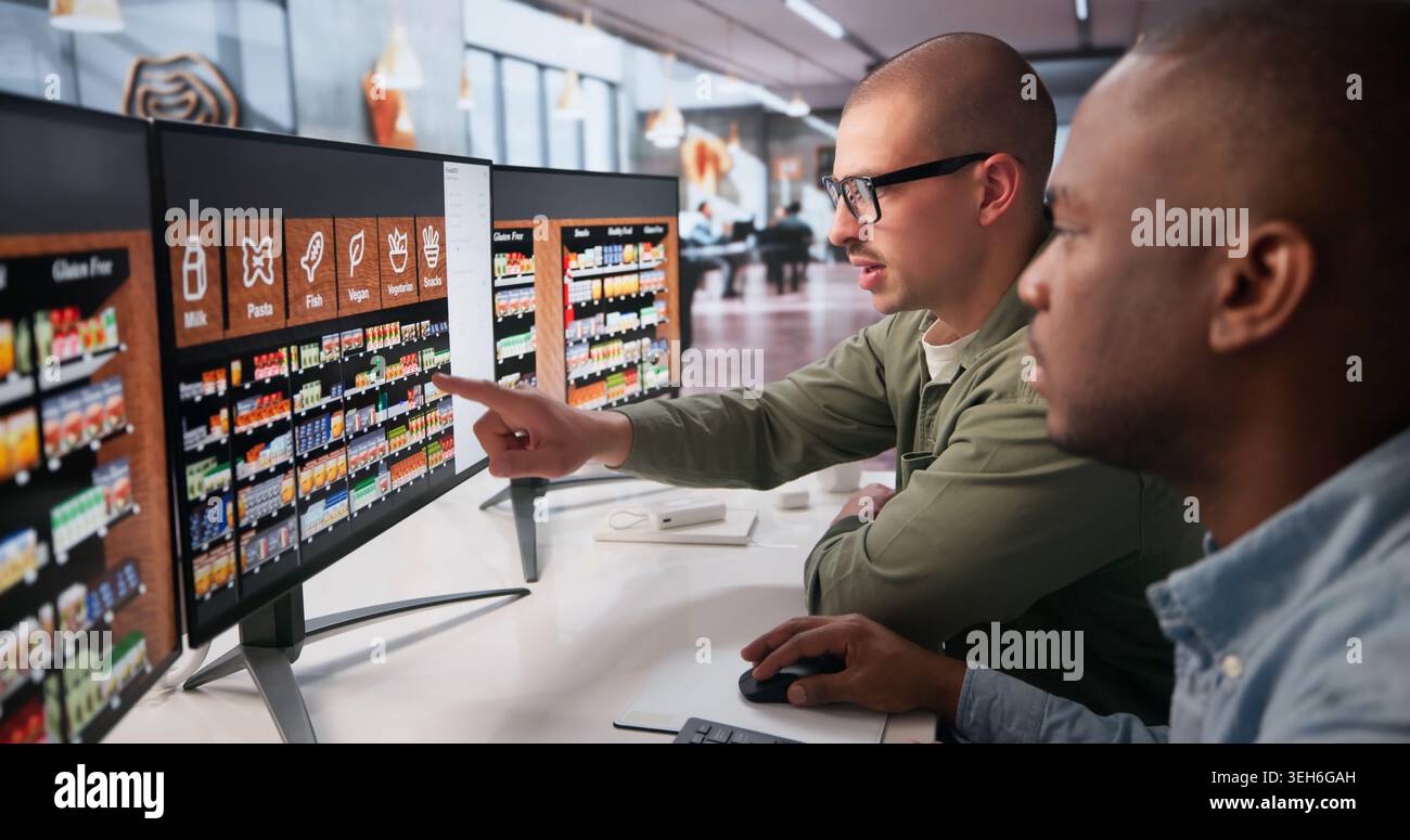 Two Retail Managers Working Together On Computer To Plan Store Layout. Stock Photo