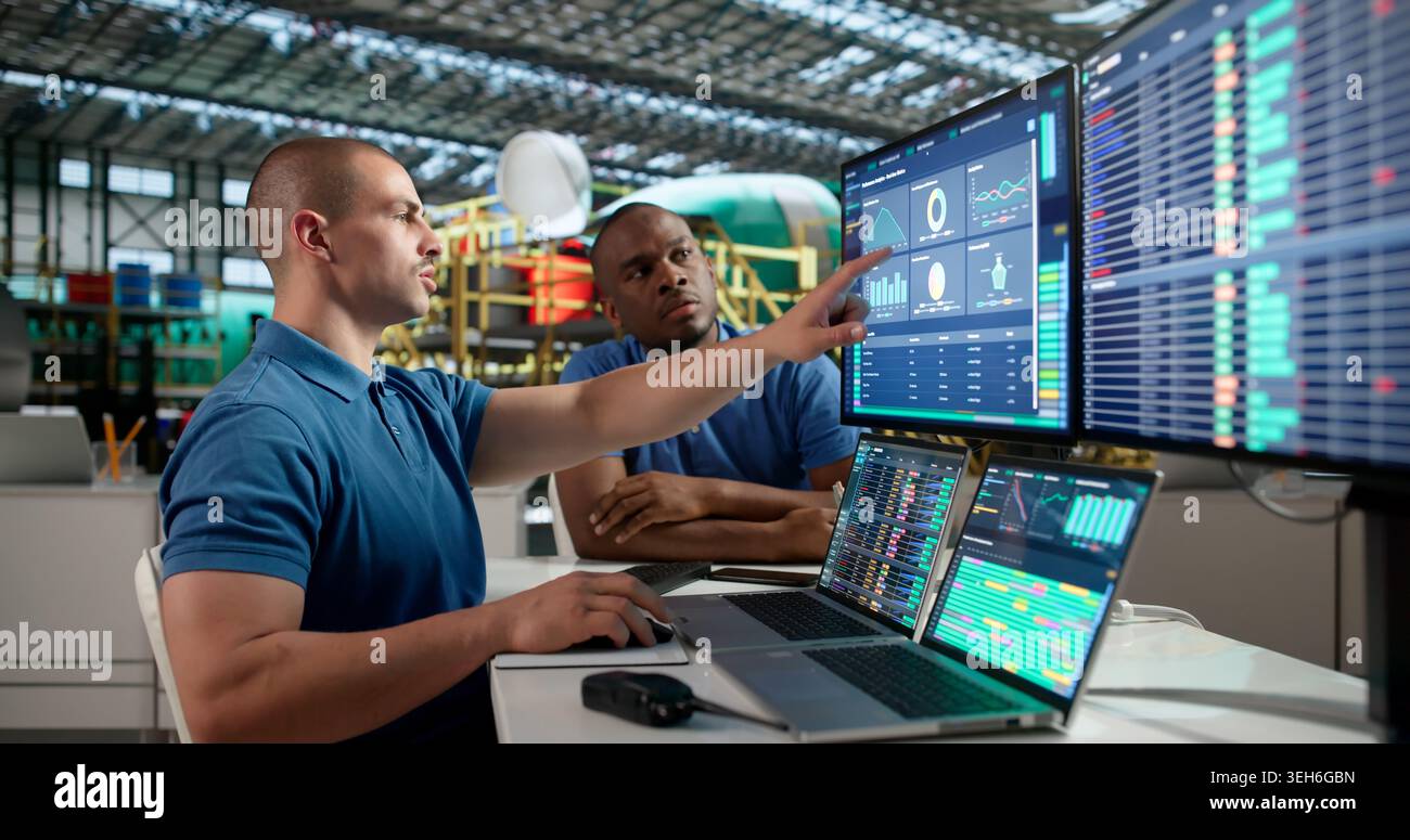 Young Aerospace Engineer Uses Laptop To Check Airplane Engine Systems. Stock Photo