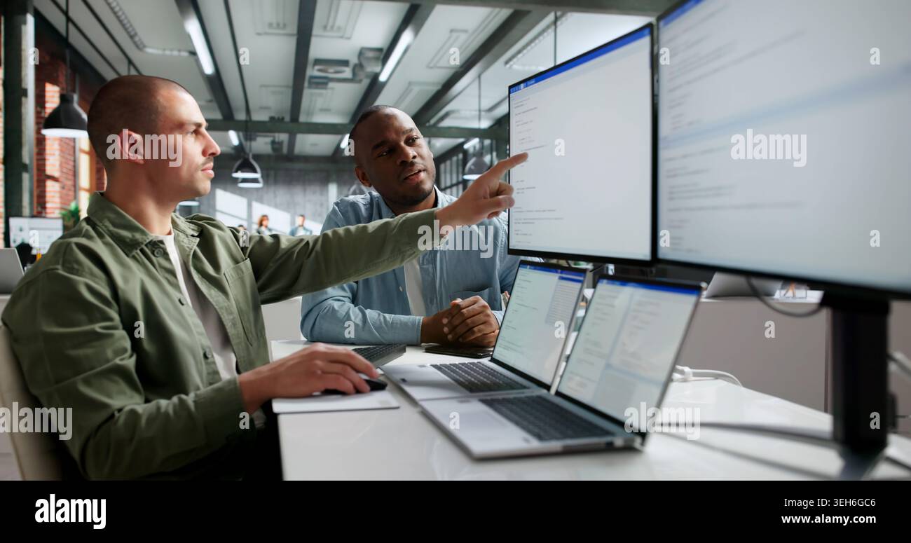 Two Software Engineers Working Together On Secure Web Application Code. Stock Photo