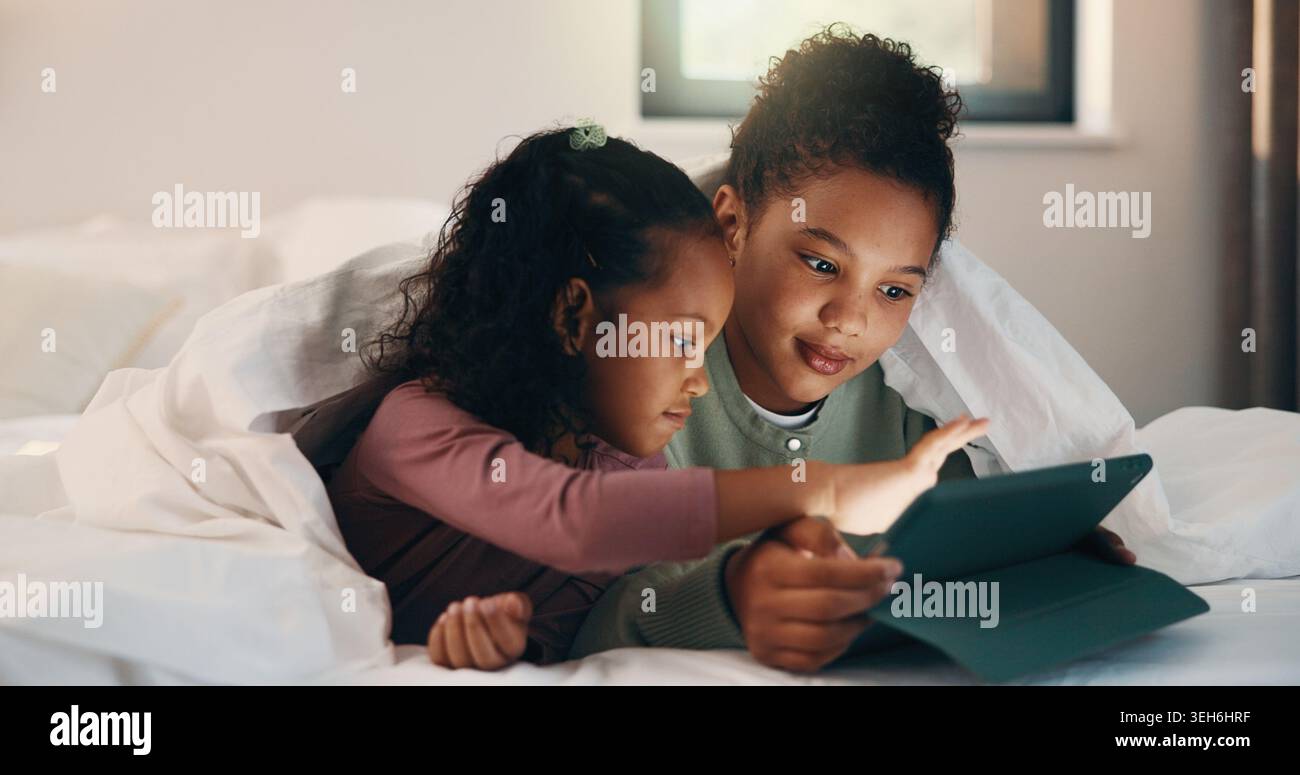 Relax, children and sisters with tablet in bed, watch cartoon or streaming video for weekend bonding. Family subscription, movie website or girls with Stock Photo