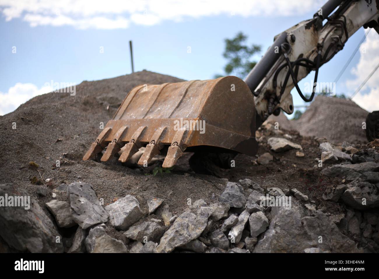 Digging Rough Stone Heavy excavator bucket digging into a massive pile of gravel and stones ...