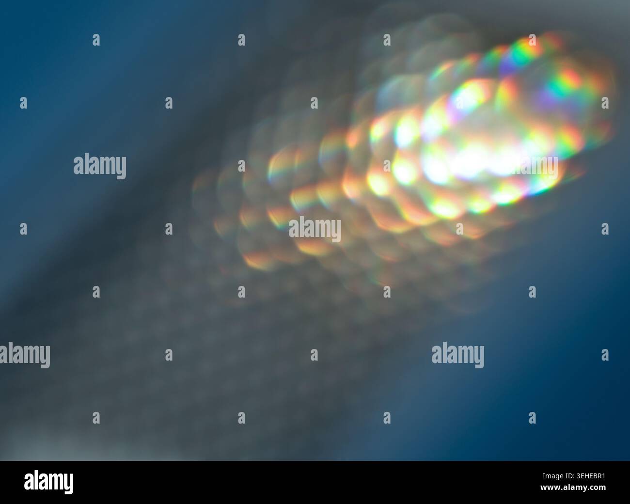 Abstract Bokeh with Rainbow Spectrum on a Soft Blue Background Stock Photo