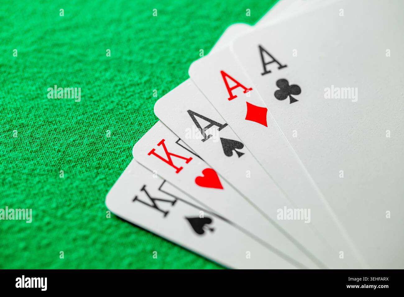 three of a kind aces and kings, set playing cards in poker on green cloth Stock Photo