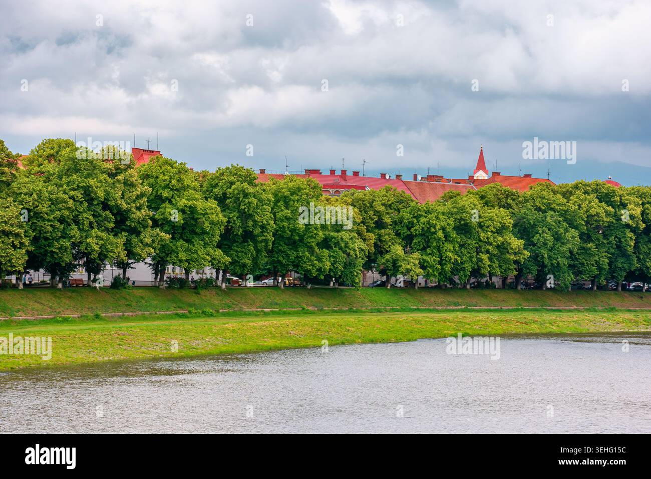 longest linden alley in europe on the Uzh river embankment. lime trees on a sunny summer afternoon. travel destination of transcarpathia. uzhhorod str Stock Photo