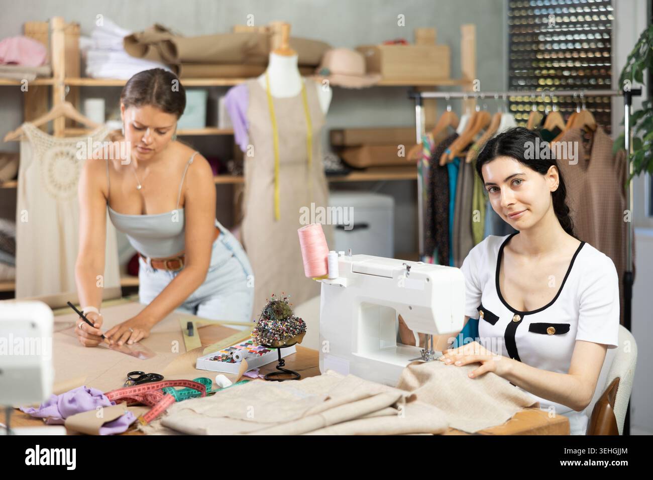 Two female tailors working on custom garment in studio Stock Photo