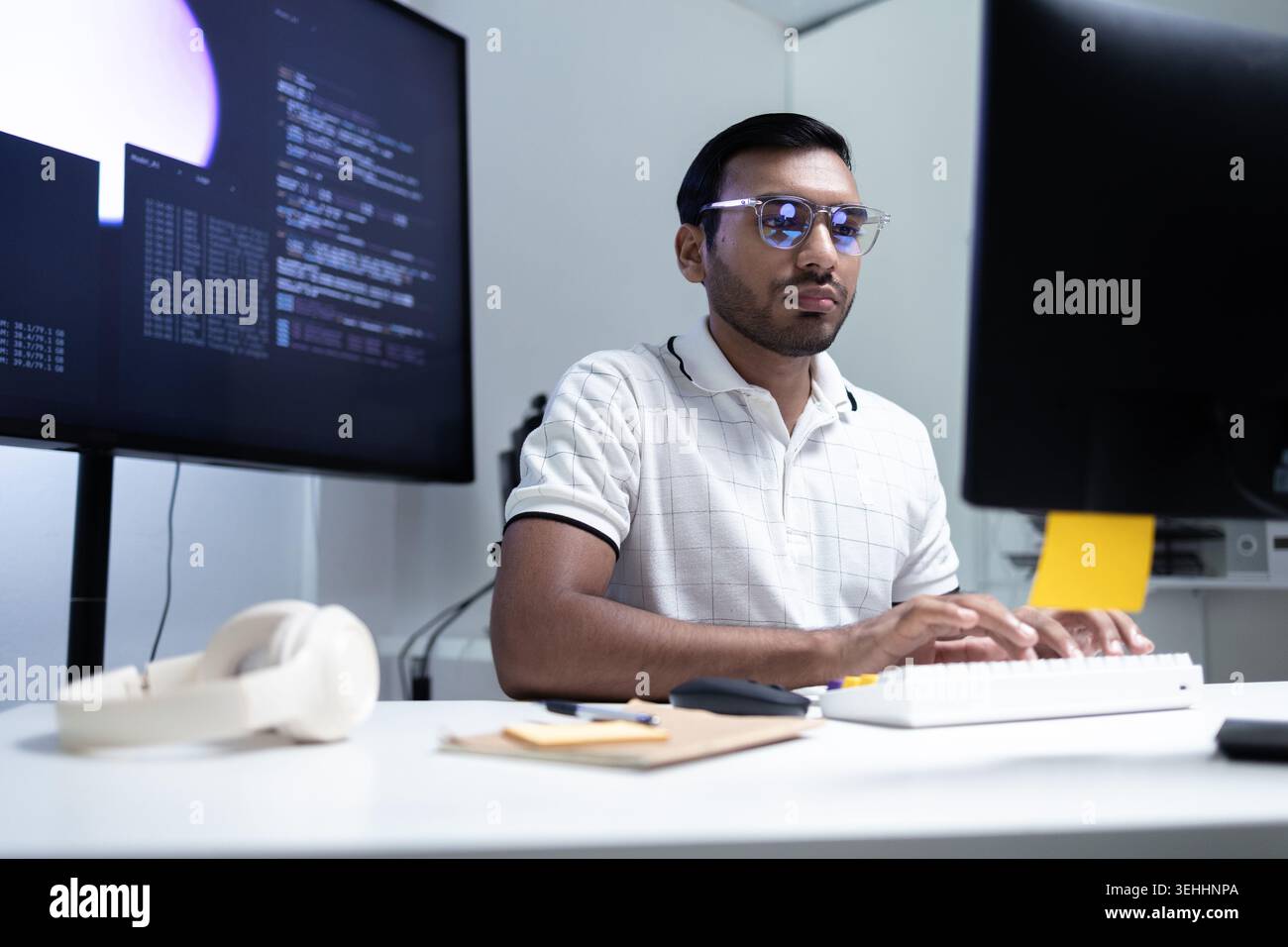 Indian Software Developer Working On AI Code In Modern Tech Office Stock Photo