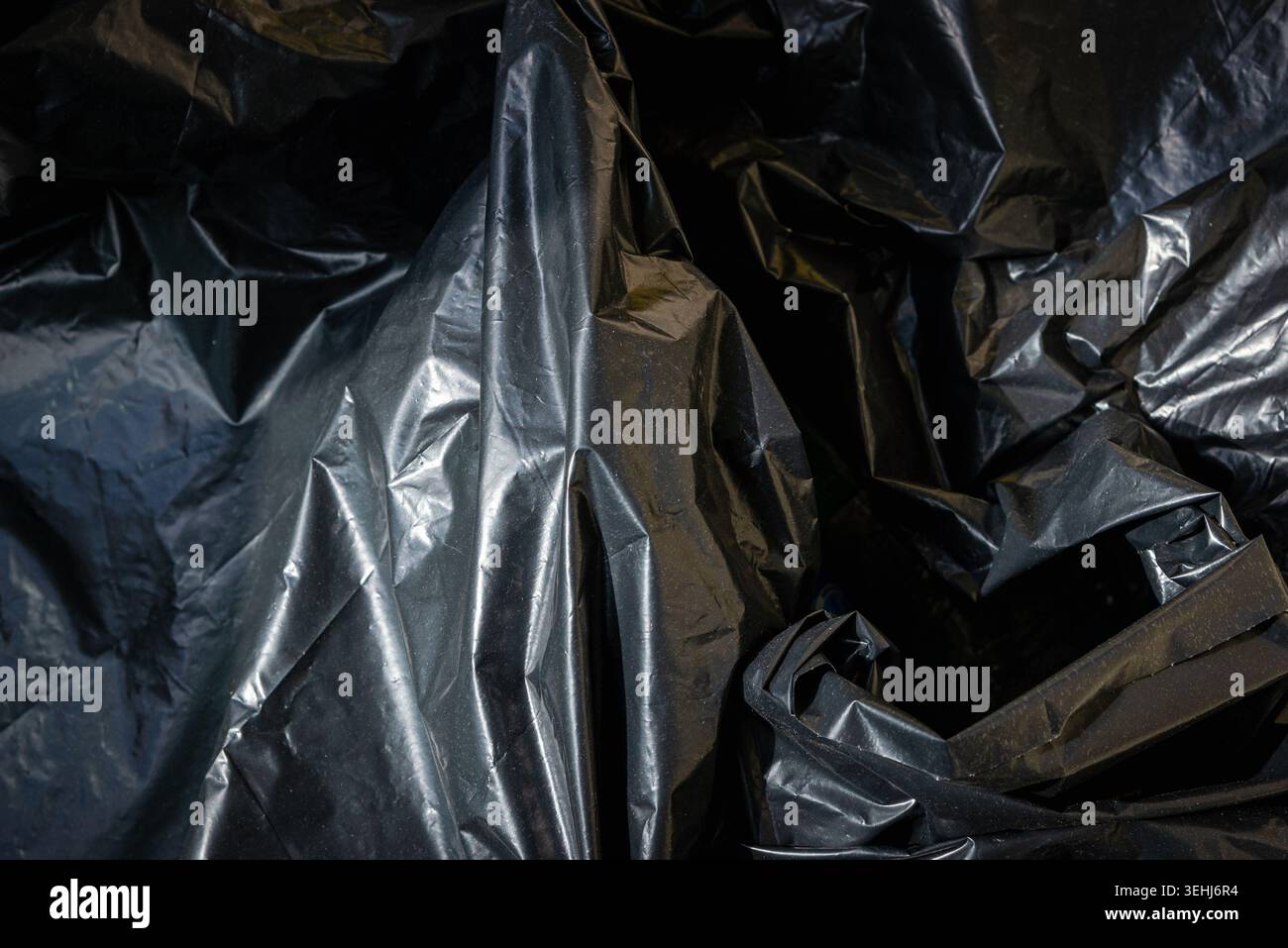 Plastic crumpled black texture garbage bag background. Stock Photo