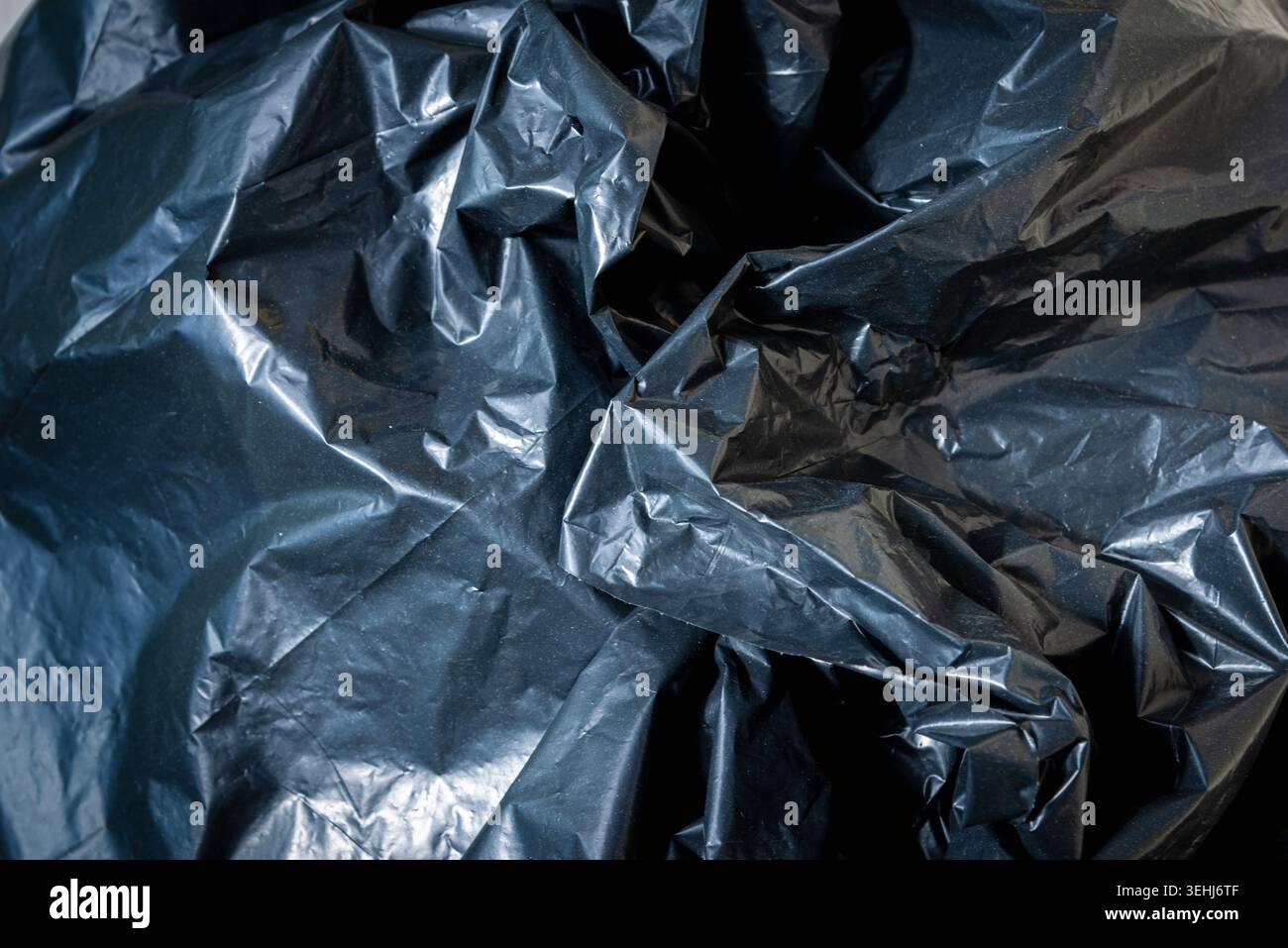 Plastic crumpled black texture garbage bag background. Stock Photo