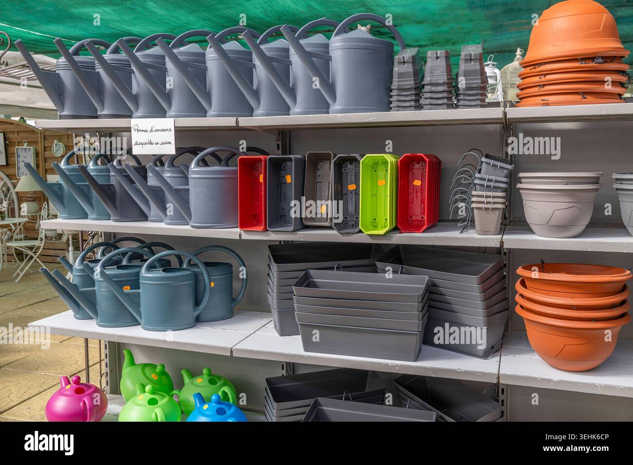 Metal shelves hold various plastic gardening supplies, including ...
