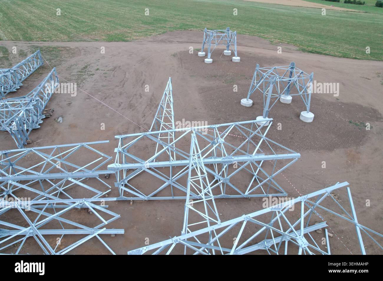 High-voltage pylon disassembled on ground with concrete bases before ...