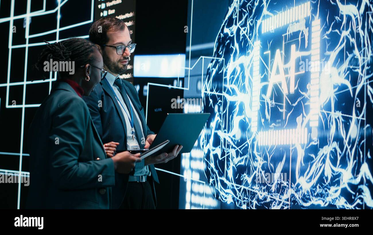 Autonomy concept, AI machine learning and engineering team looking at self writing code on screen, artificial intelligence and teamworking colleagues reviewing self sustaining AI model Stock Photo