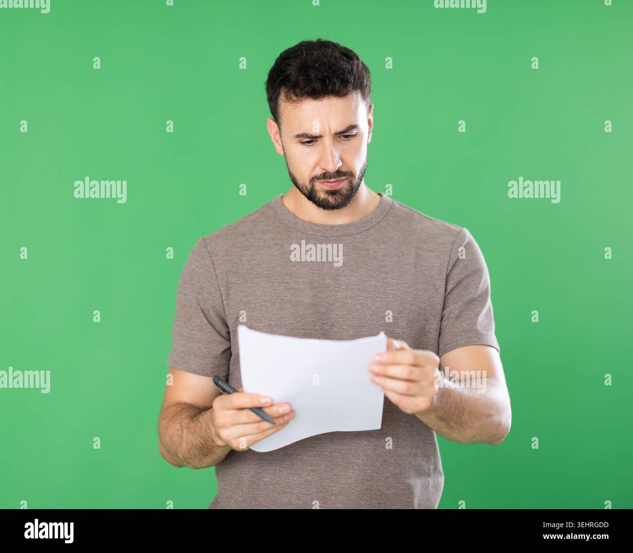 Adult man making notes on paper documents in front of green screen Stock Photo