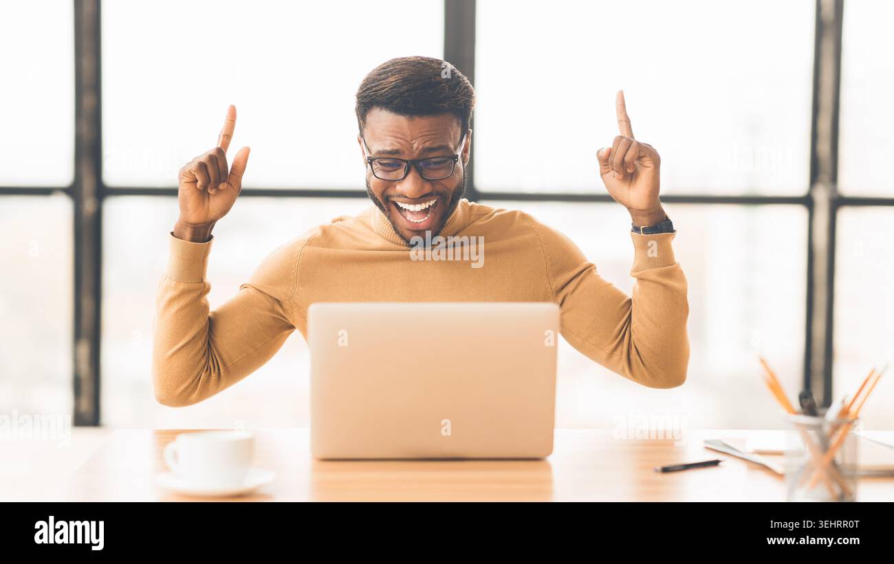 Ecstatic afro guy found new good idea Stock Photo