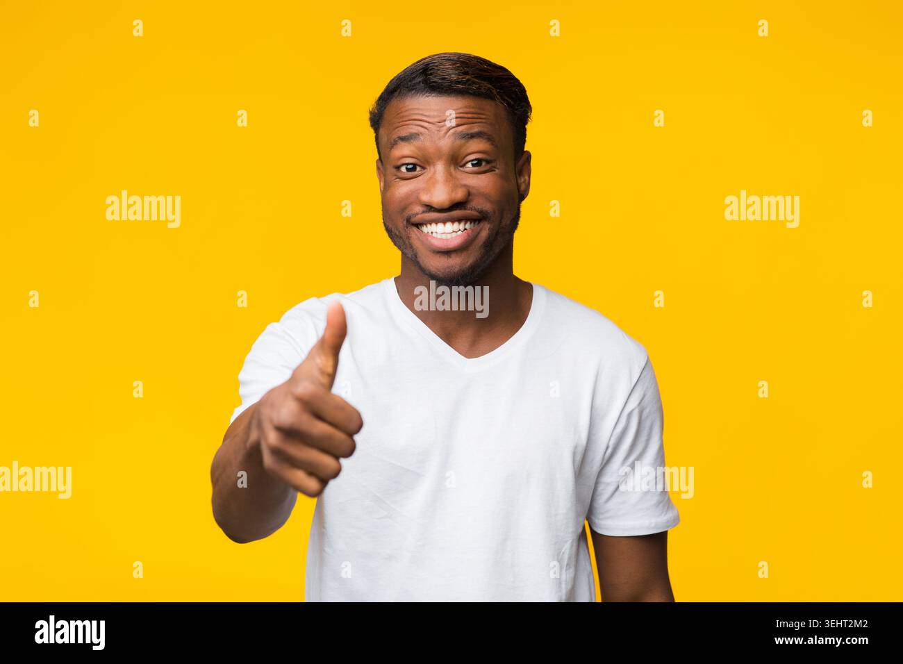 Smiling Afro Guy Gesturing Thumbs Up Approving Something, Studio Shot Stock Photo