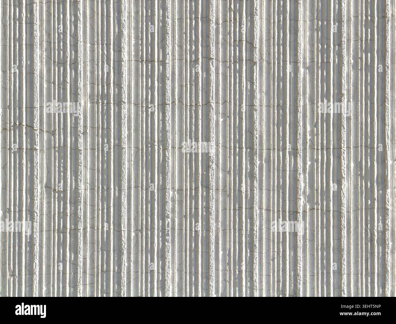 white painted rough ribbed plaster wall with fine cracks. vertical stripes pattern. Stock Photo