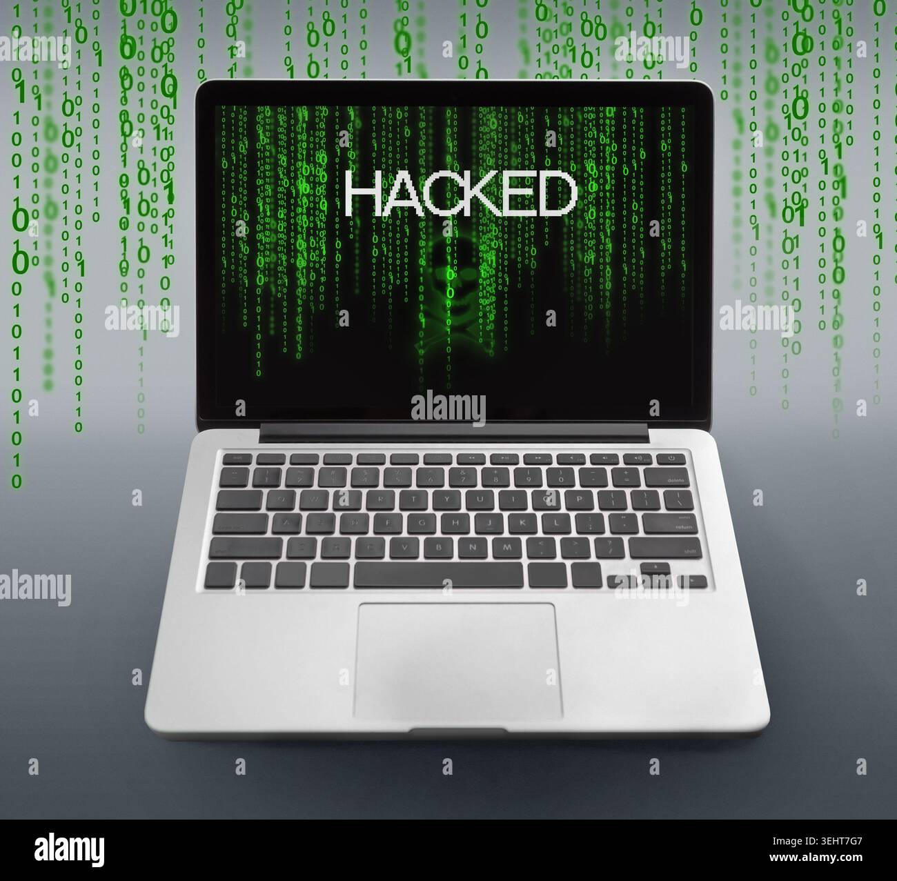 Laptop with hacked message and binary code numbers on screen Stock Photo