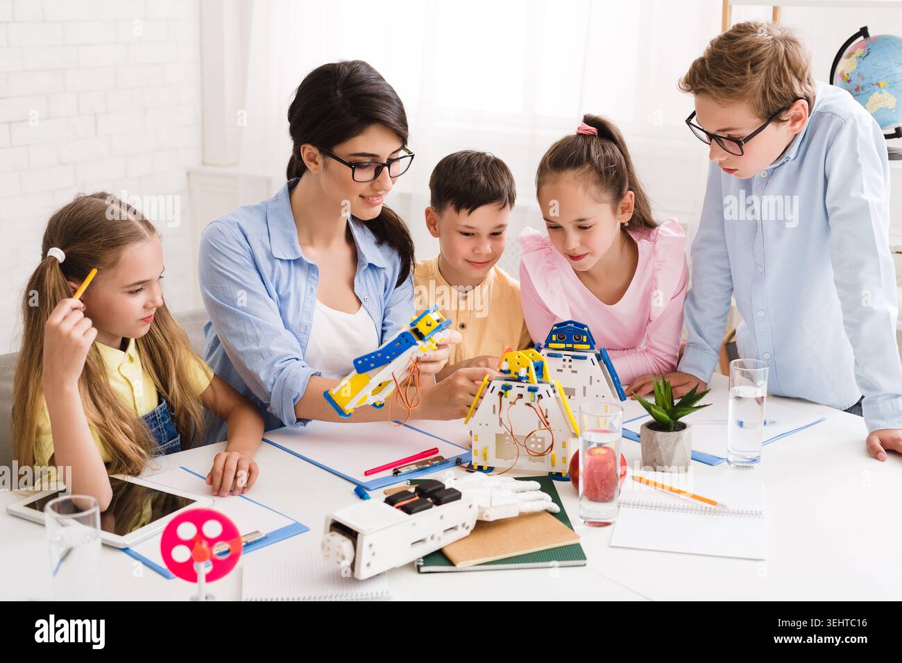 Engaging Classroom Activity With Students Exploring Robotics and Creativity in a Bright Space Stock Photo