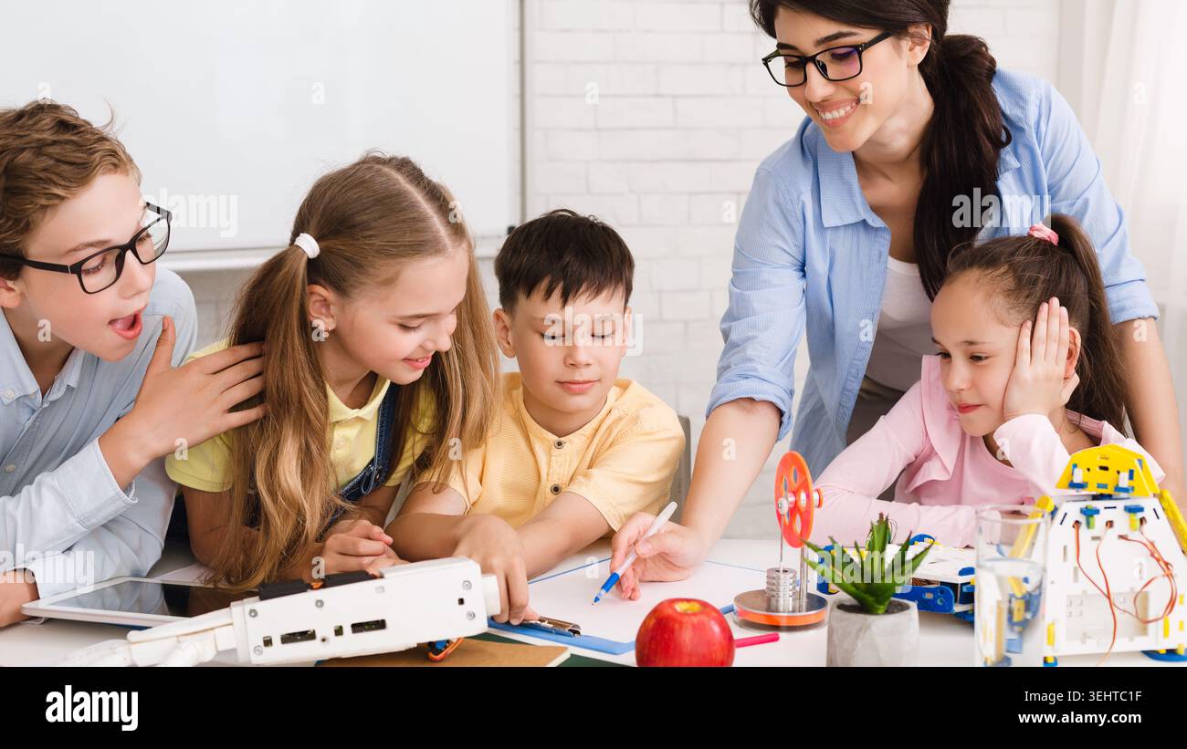 Children Engaged in a Creative Learning Activity With Robotics and Technology in a Classroom Stock Photo