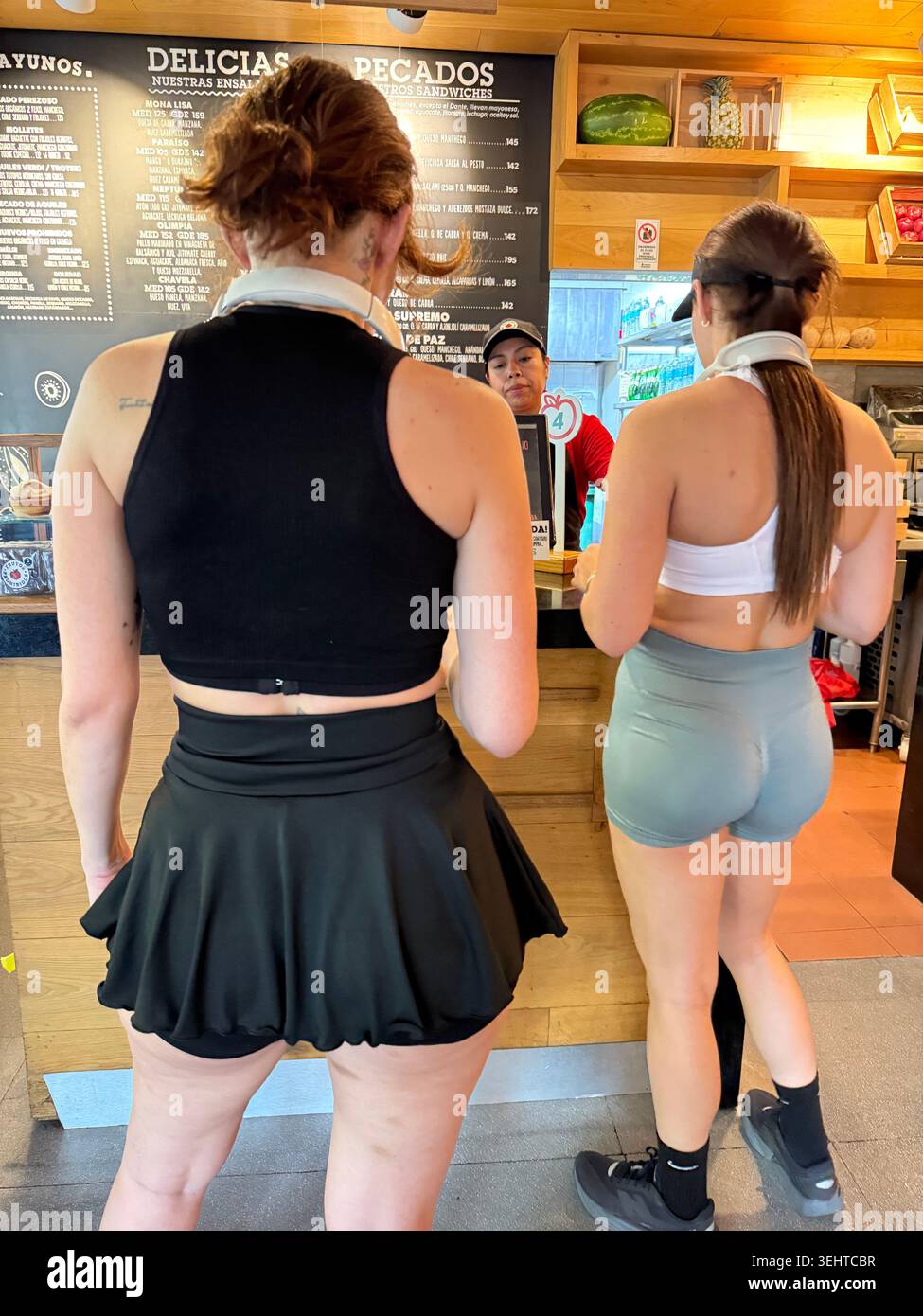 Women in athletic wear order at a stylish café in La Condesa, Mexico City, reflecting the neighborhood’s trendy fitness culture, café scene and ongoin - Smartphone Captured Stock Image