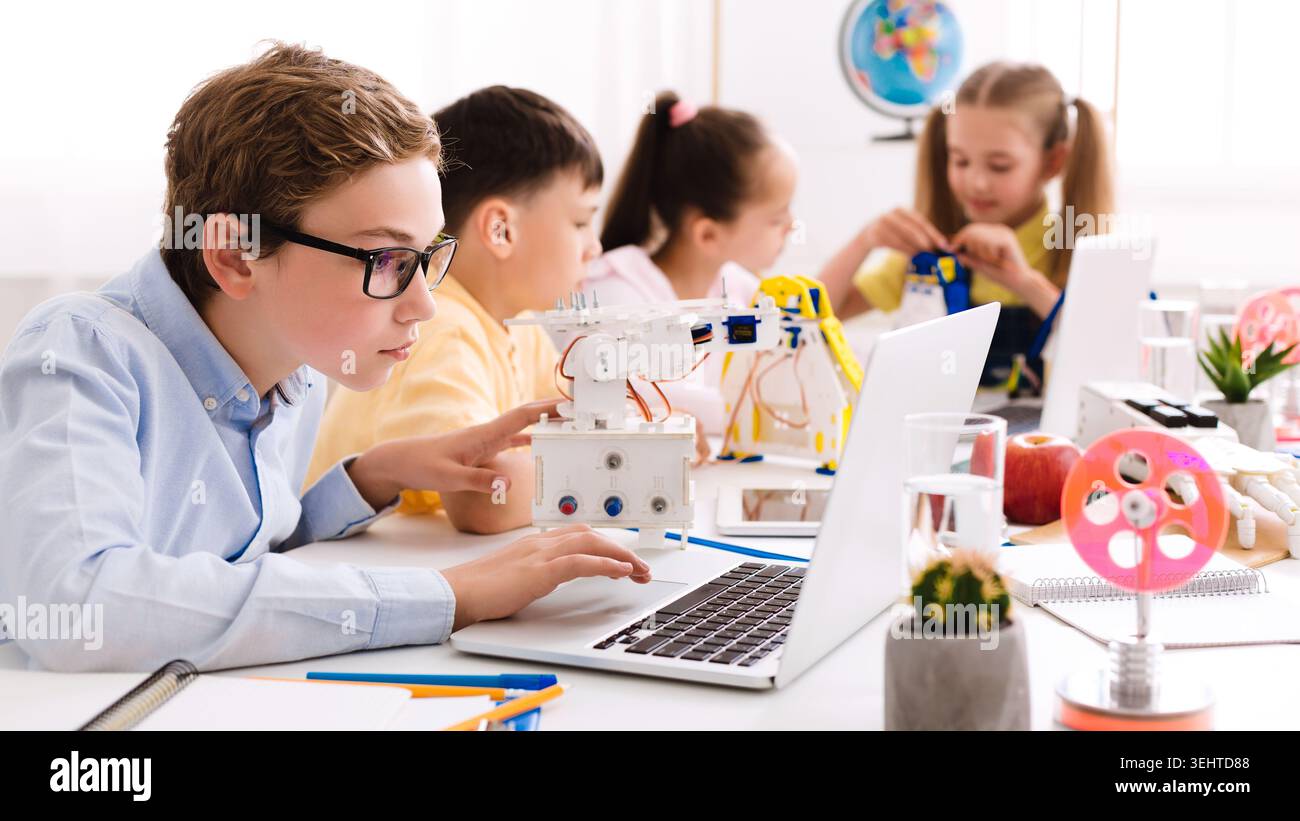 Children Engaged in Robotics and Programming Activities in a Modern Classroom Setup Stock Photo