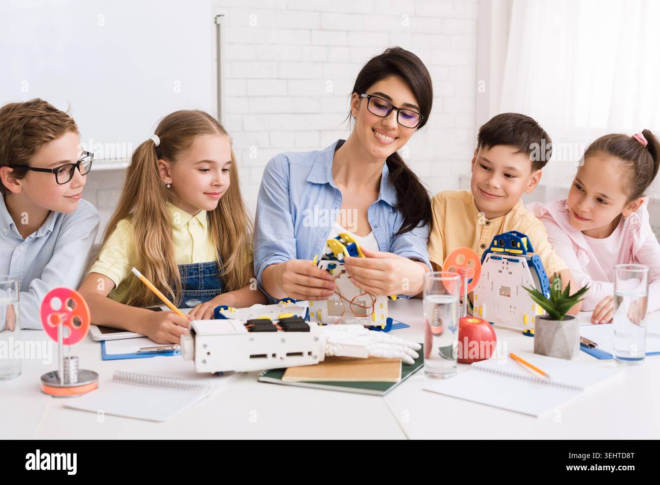 Children Engaged in Robotics Workshop With Instructor at Learning Center Stock Photo