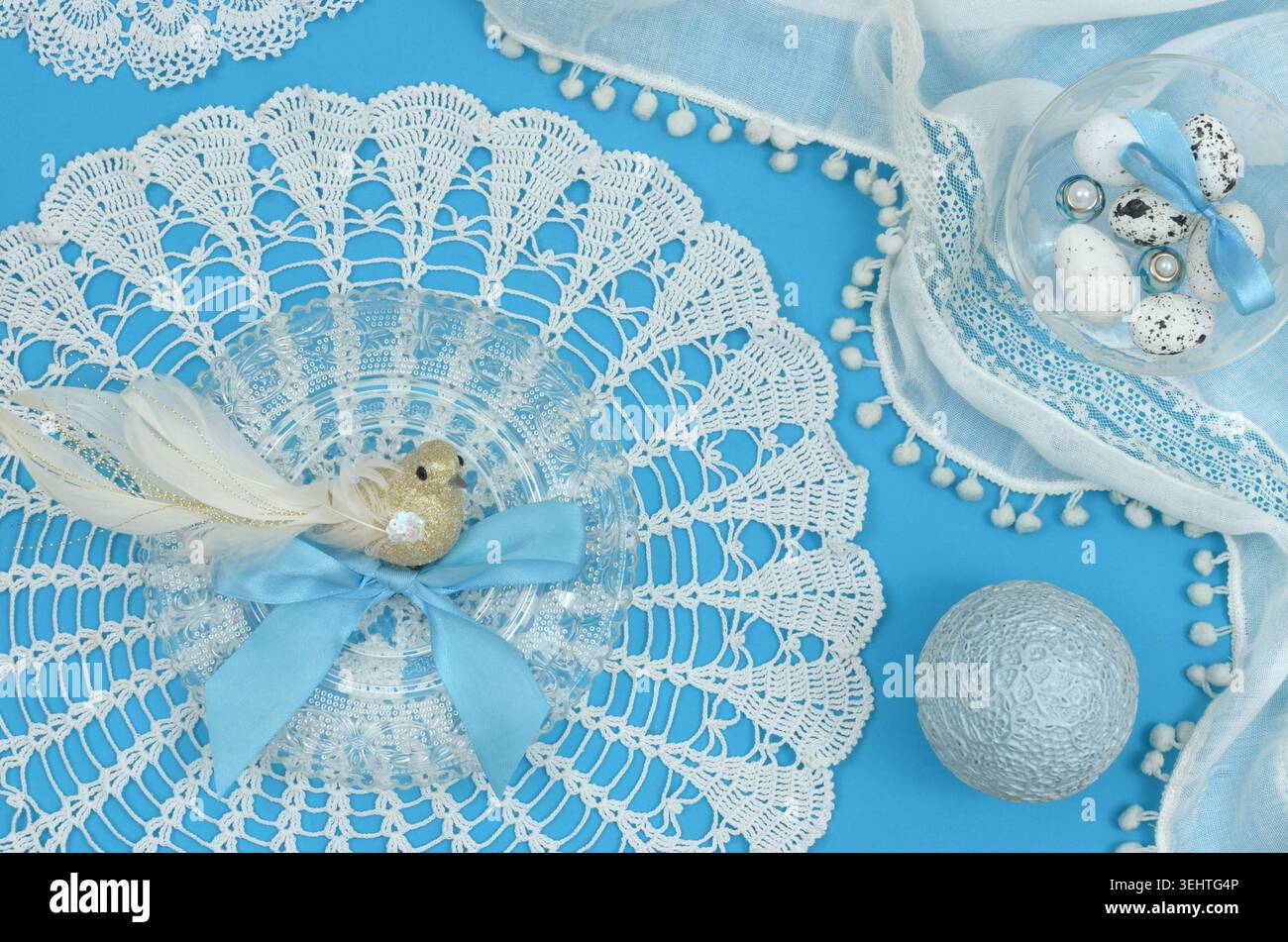 Blue, elegant decoration with vintage lace, decorative bird, egg and feminine decorations on blue table. Stock Photo
