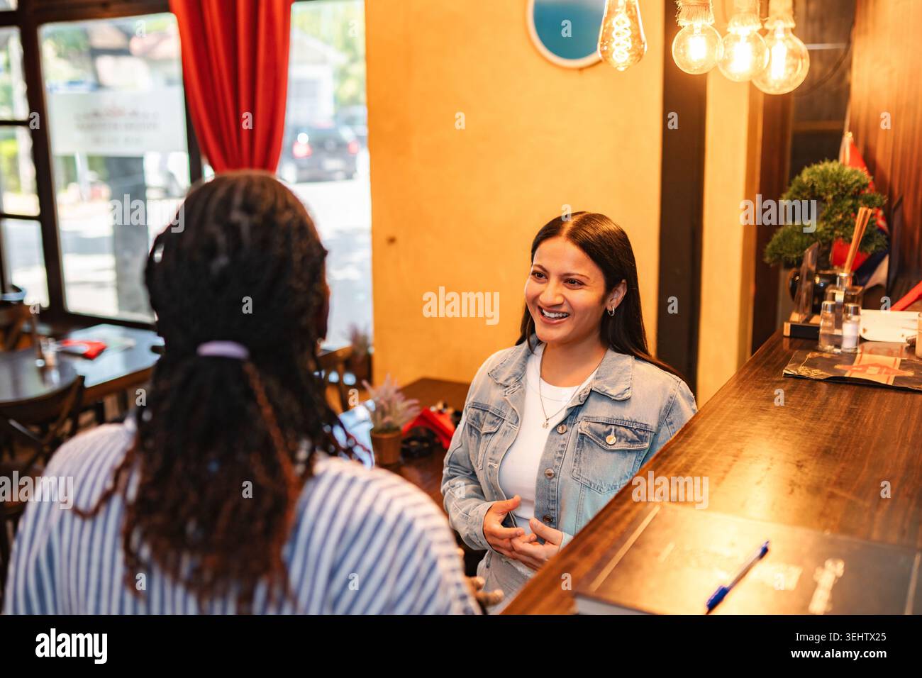 Two women having conversation at restaurant bar area Stock Photo