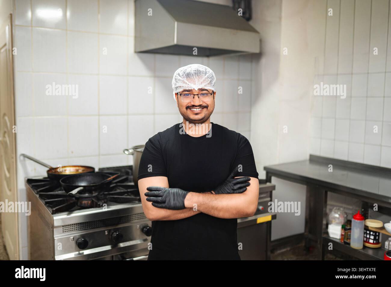 Smiling professional chef standing in commercial kitchen Stock Photo