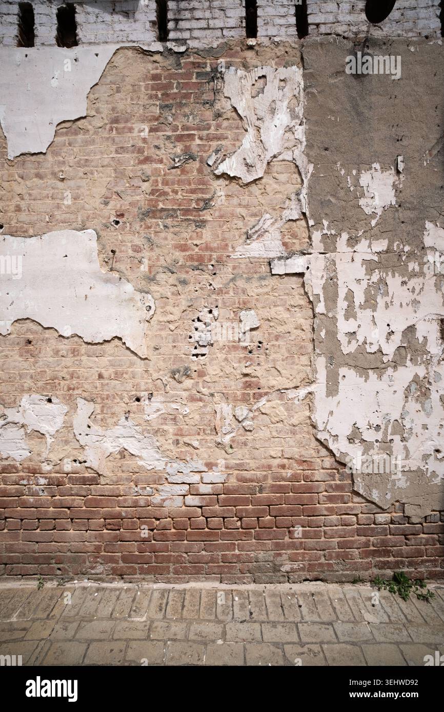 Weathered brick wall and peeling plaster Stock Photo