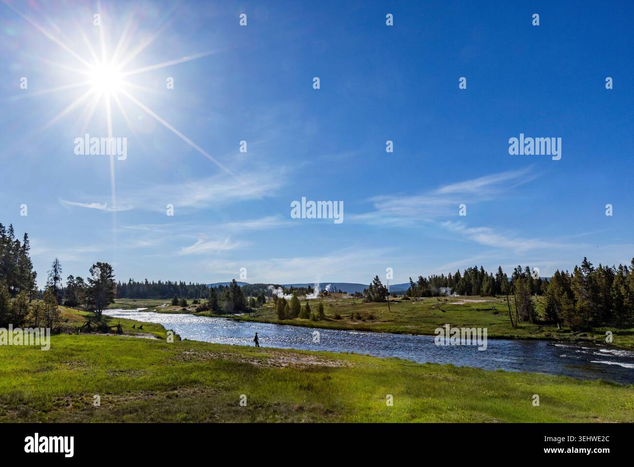 Sun on blue sky over Firehole River Stock Photo